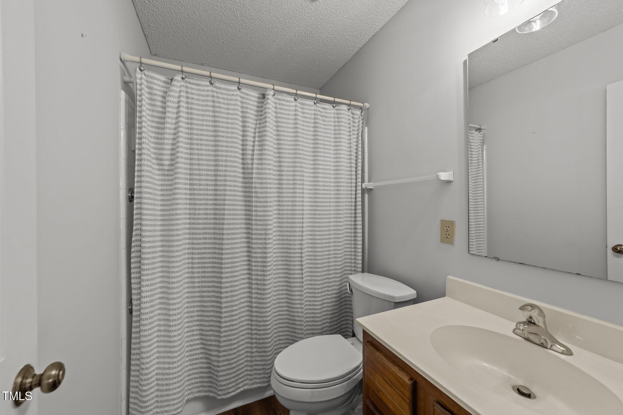 6817 Fairpoint Court Raleigh, NC 27613 - Photo 13 of 25 a bathroom with a sink a toilet and mirror