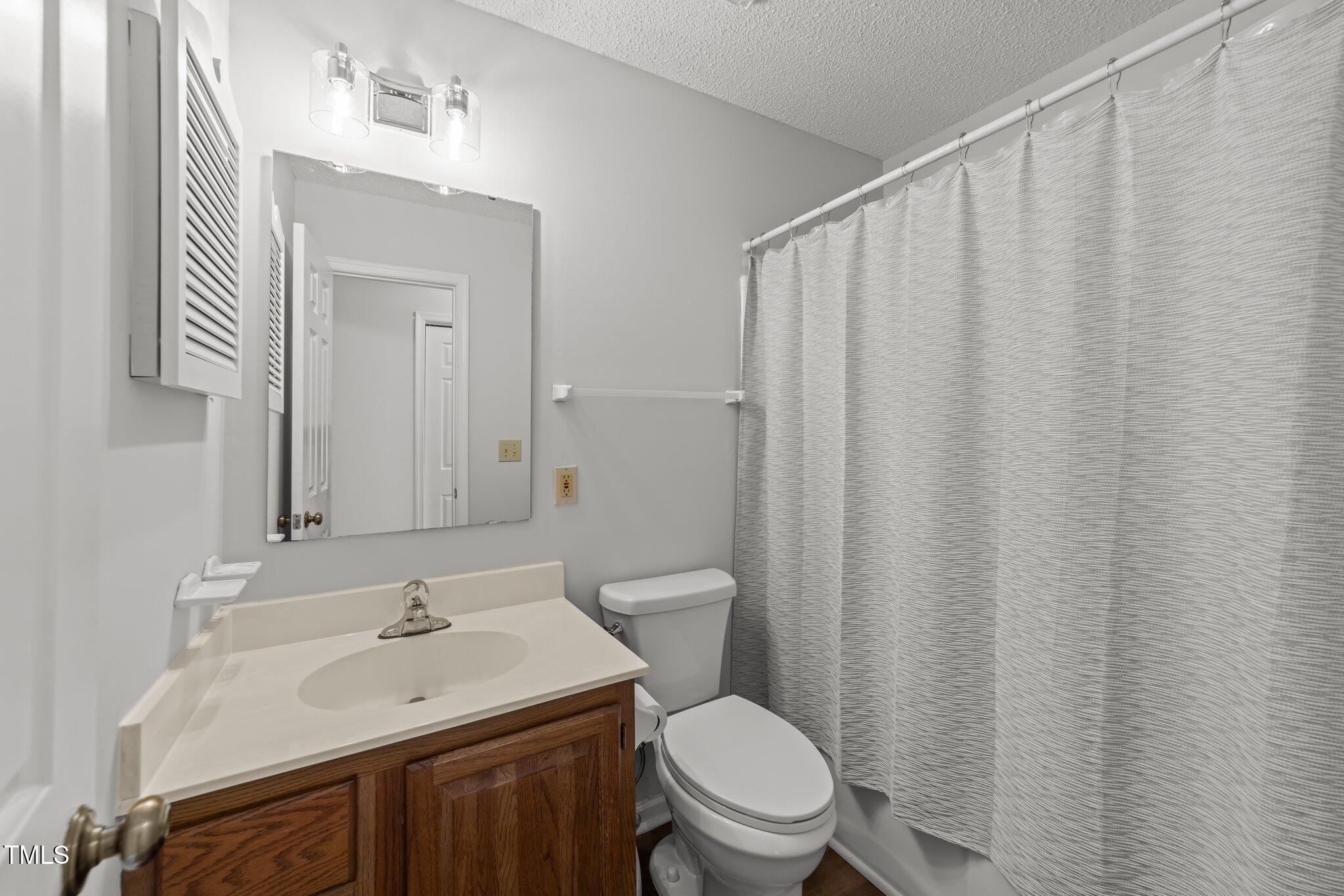 6817 Fairpoint Court Raleigh, NC 27613 - Photo 16 of 25 a bathroom with a sink a toilet and shower