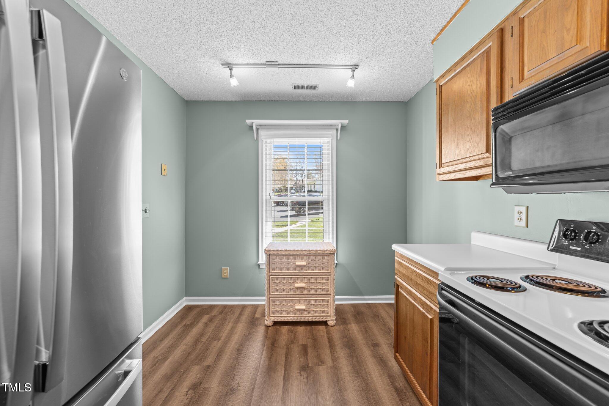 6817 Fairpoint Court Raleigh, NC 27613 - Photo 7 of 25 a kitchen that has a stove and a microwave