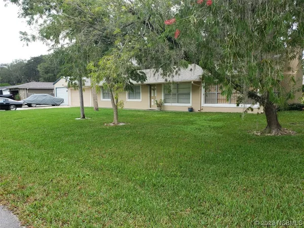 a view of an house with backyard space and garden