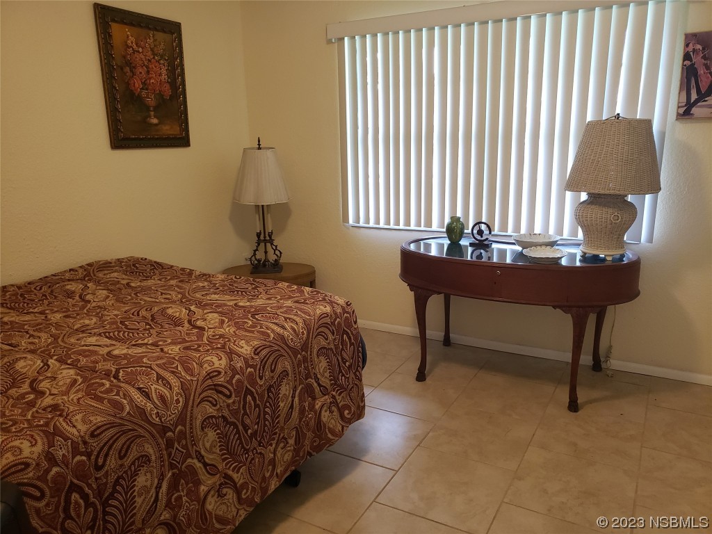 1867 Pine Tree Drive Edgewater, FL 32141 - Photo 11 of 21 a bedroom with a bed and a lamp on dresser