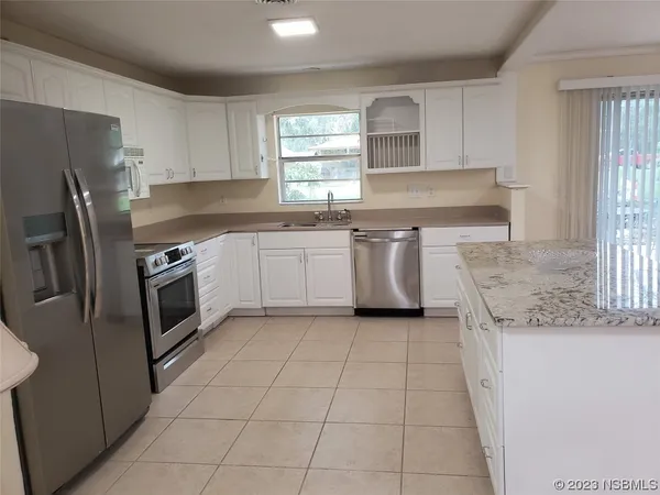 a kitchen with cabinets and chairs