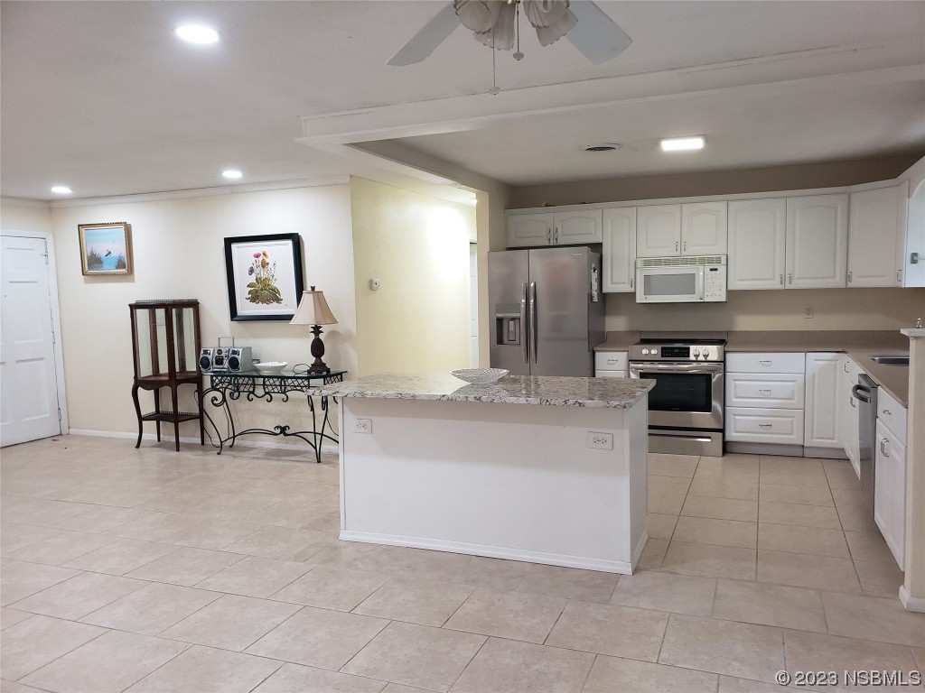 1867 Pine Tree Drive Edgewater, FL 32141 - Photo 18 of 21 a kitchen with cabinets and chairs