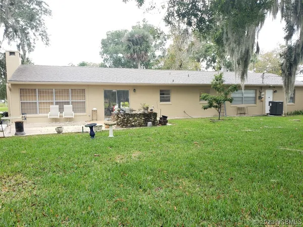 a view of a backyard with table and chairs and potted plants