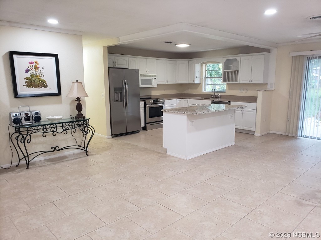 1867 Pine Tree Drive Edgewater, FL 32141 - Photo 5 of 21 a kitchen with stainless steel appliances a refrigerator sink and cabinets