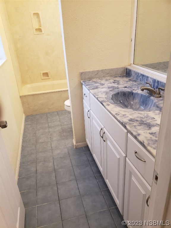 1867 Pine Tree Drive Edgewater, FL 32141 - Photo 10 of 21 a bathroom with a granite countertop sink a toilet and bathtub