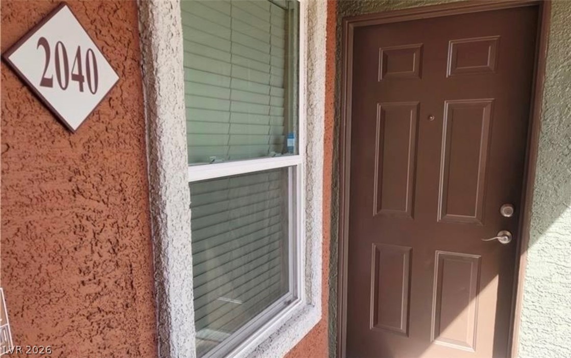 8101 West Flamingo Road, Unit 2040 Las Vegas, NV 89147 - Photo 3 of 4 An inviting entryway presents textured stucco walls and a classic paneled front door.