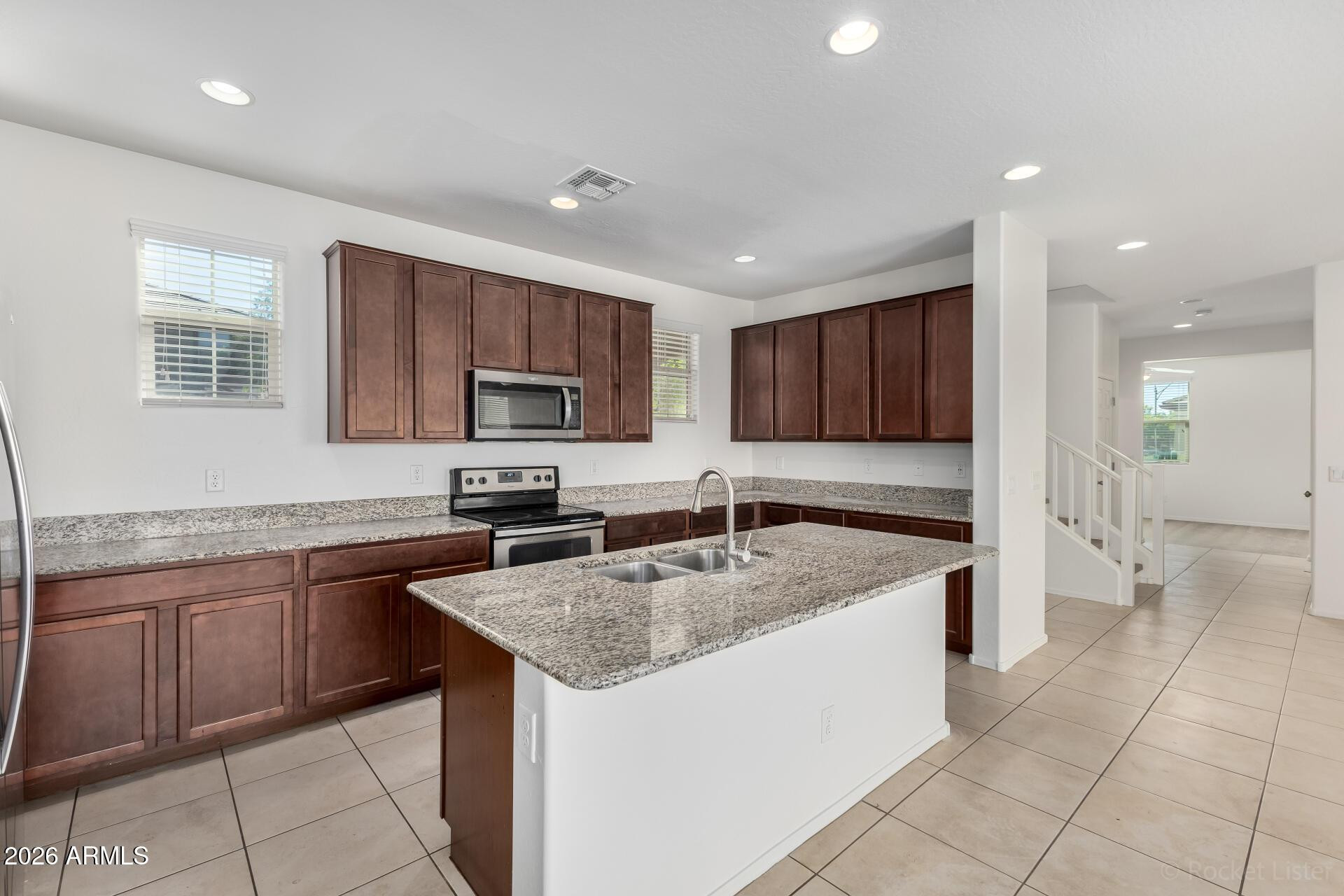 4084 East Ranch Road Gilbert, AZ 85296 - Photo 8 of 33 a kitchen with stainless steel appliances granite countertop a sink counter space cabinets and a large window