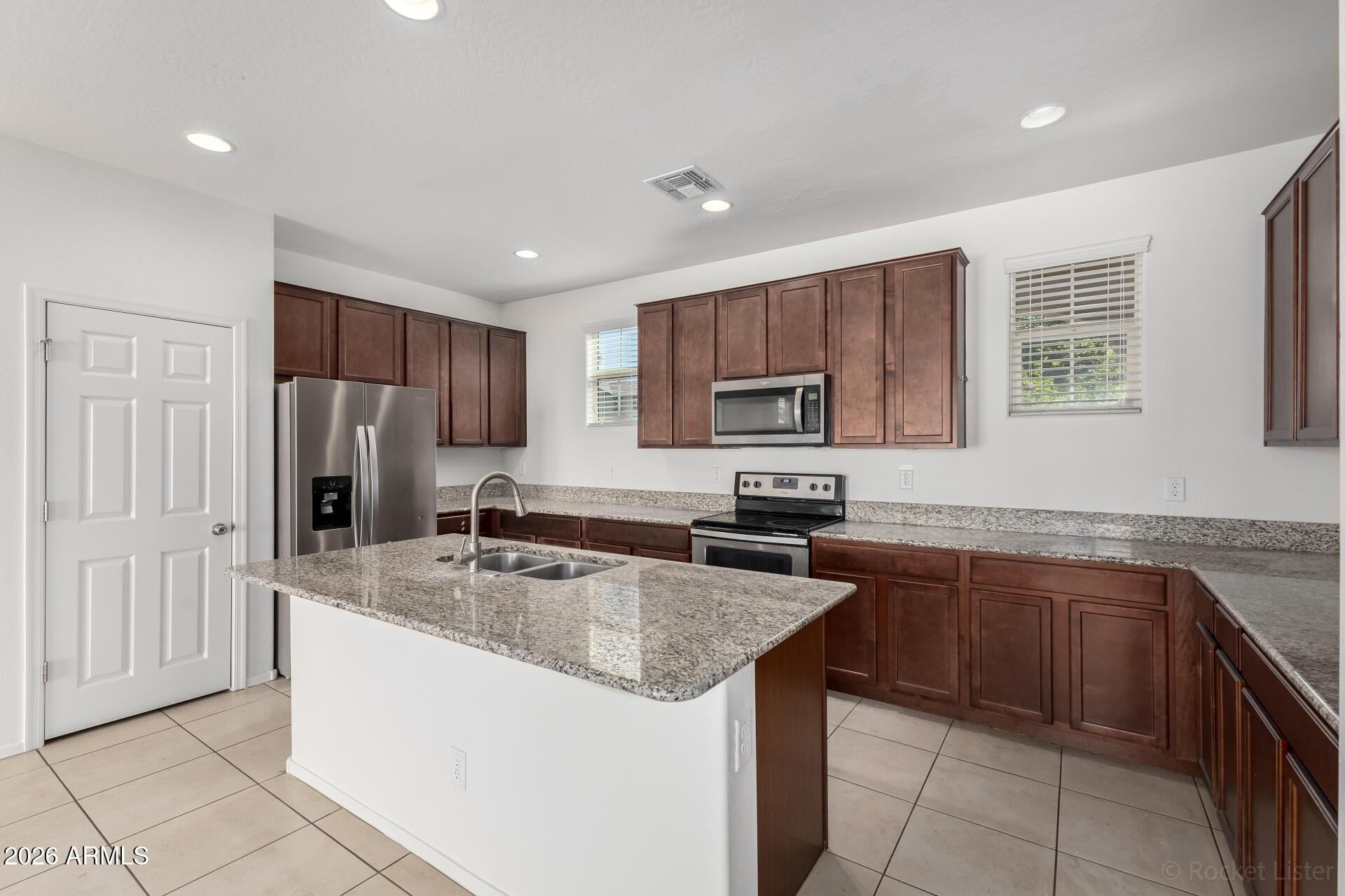 4084 East Ranch Road Gilbert, AZ 85296 - Photo 10 of 33 a kitchen with stainless steel appliances granite countertop a sink stove microwave and refrigerator