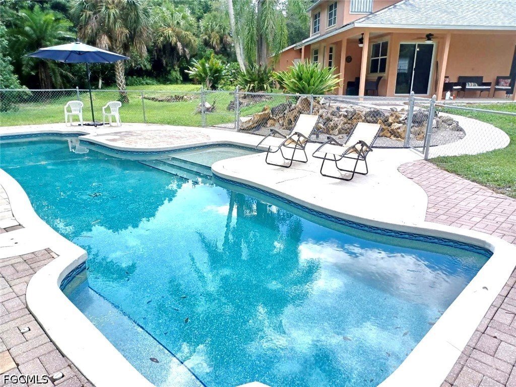 a view of a house with backyard and sitting area