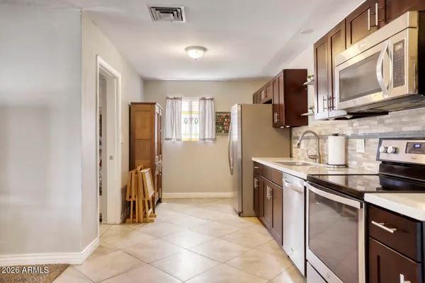 a kitchen with stainless steel appliances granite countertop a refrigerator and a stove top oven