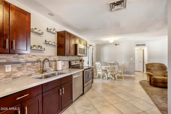 a kitchen with stainless steel appliances granite countertop a refrigerator a stove top oven a sink and dishwasher