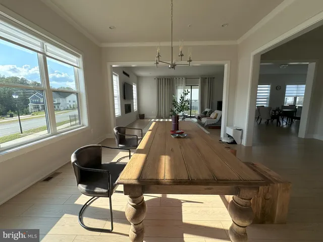a kitchen with a dining table chairs and chandelier