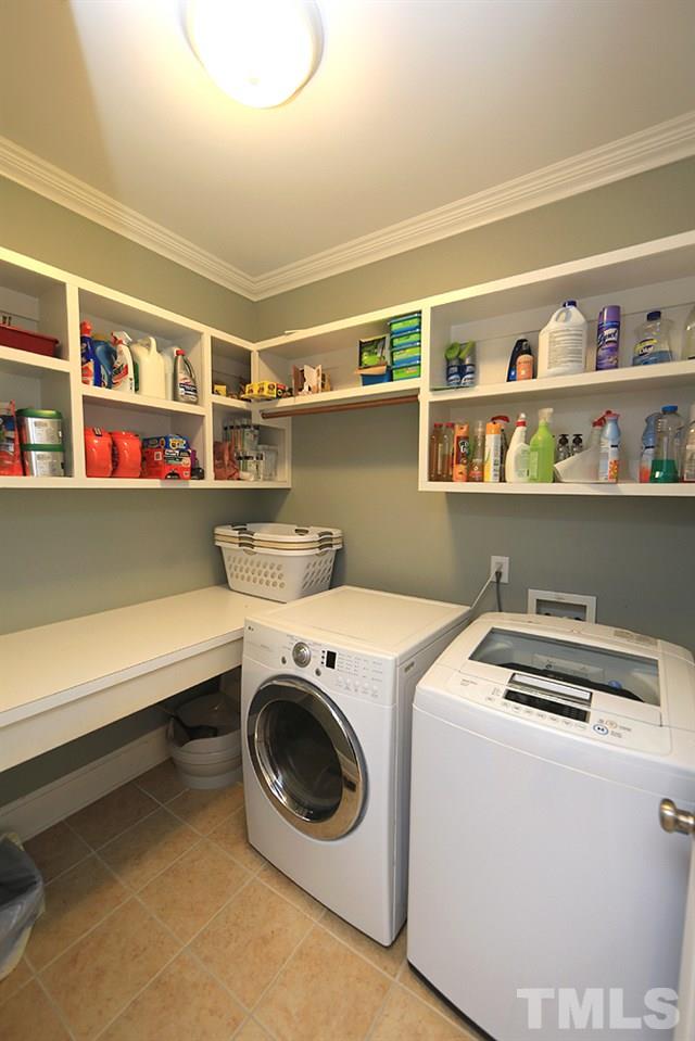 8215 Ortin Lane Raleigh, NC 27612 - Photo 15 of 29 Huge Laundry Room with counter space and wooden shelving!