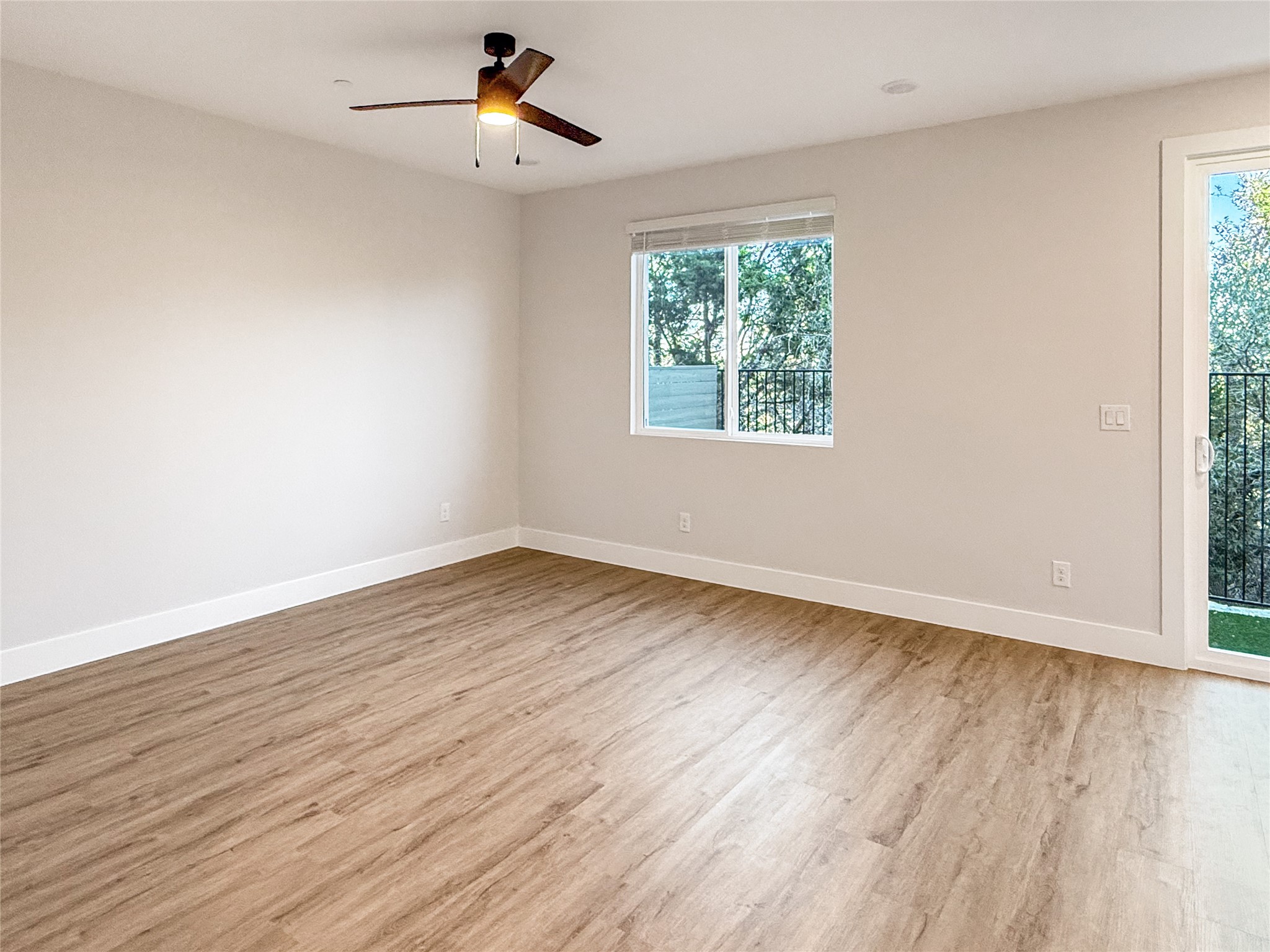 5611 Mobeetie Loop Bee Cave, TX 78738 - Photo 4 of 22 an empty room with wooden floor ceiling fan and windows