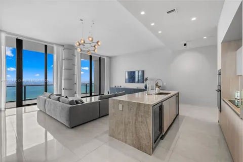 a kitchen with kitchen island granite countertop a sink and a stove
