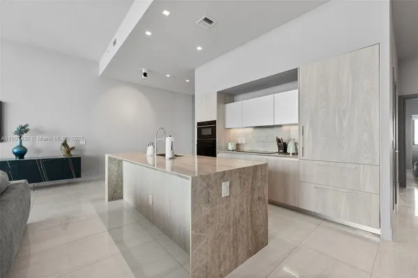 a large white kitchen with cabinets