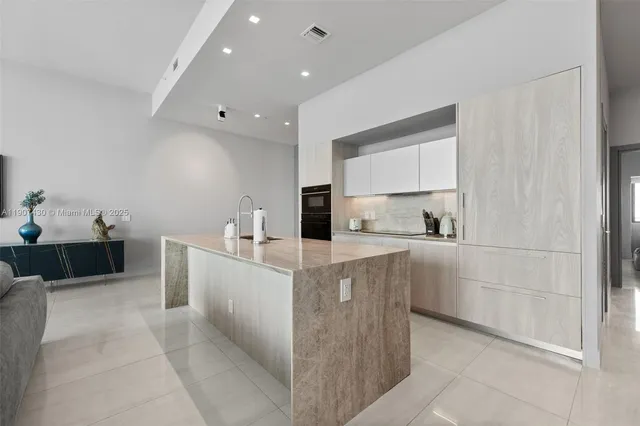 a large white kitchen with cabinets