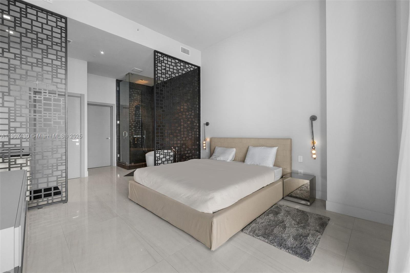 480 Northeast 31st Street, Unit PH5002 Miami, FL 33137 - Photo 8 of 15 a spacious bedroom with a bed and a couch