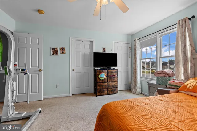 a bedroom with a bed and a flat tv screen on dresser