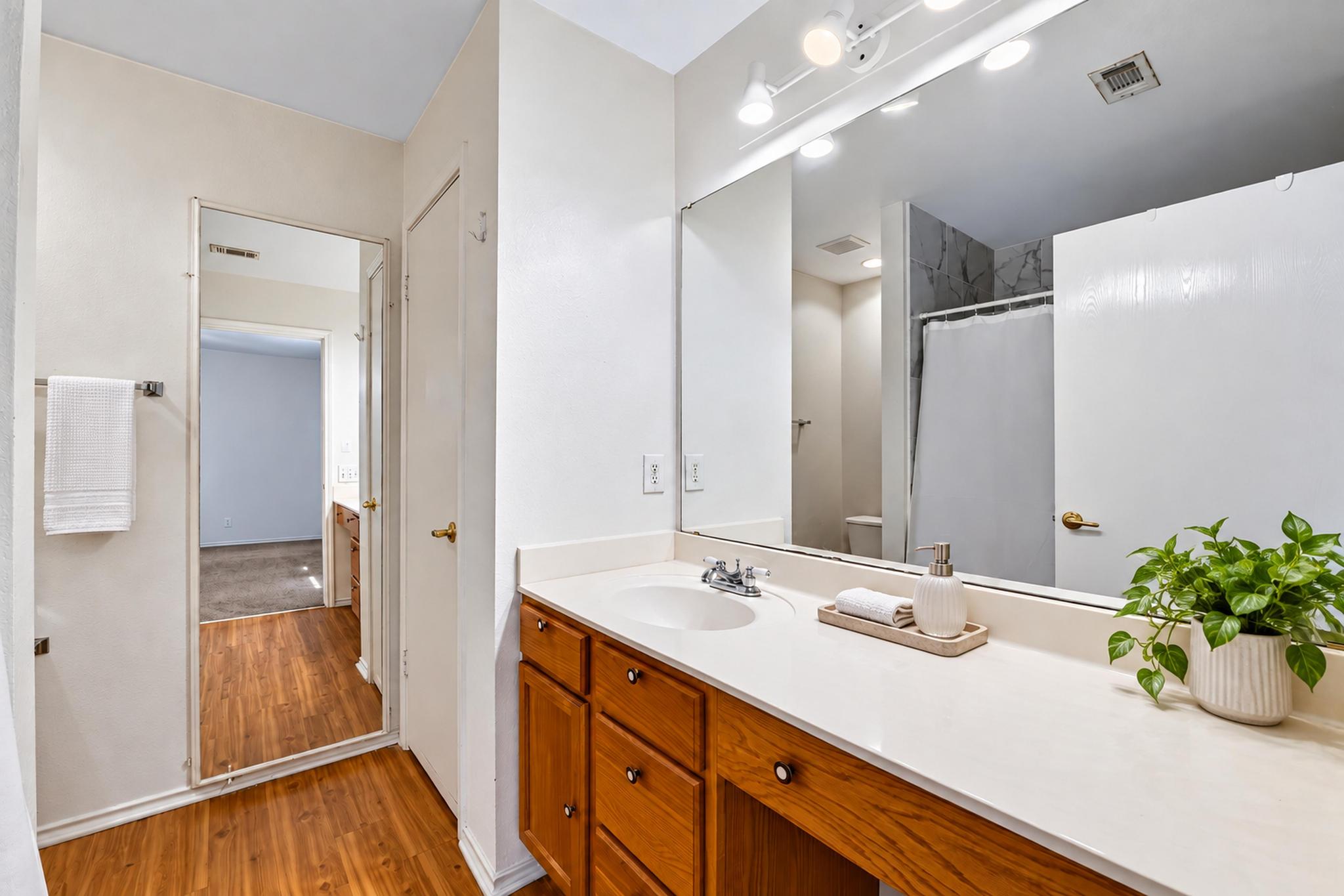 7317 Marble Ridge Drive Austin, TX 78747 - Photo 20 of 30 An expansive vanity mirror complements wood cabinetry and smooth solid-surface countertops in this classic bathroom.