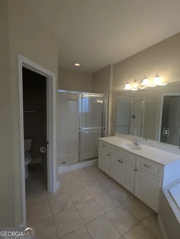 a bathroom with a glass door shower a sink and a mirror