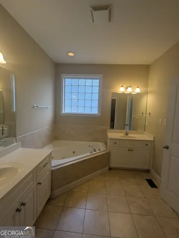 a bathroom with a bathtub a sink and a large mirror