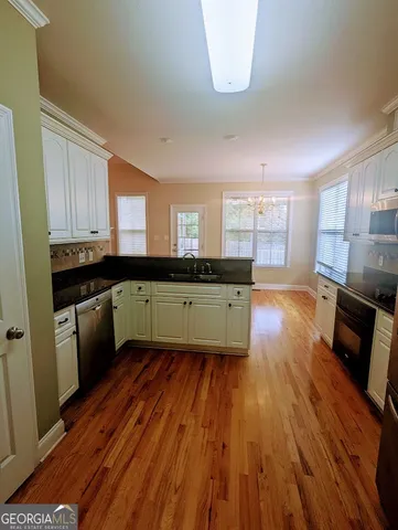 a kitchen with wooden floors and wooden cabinets