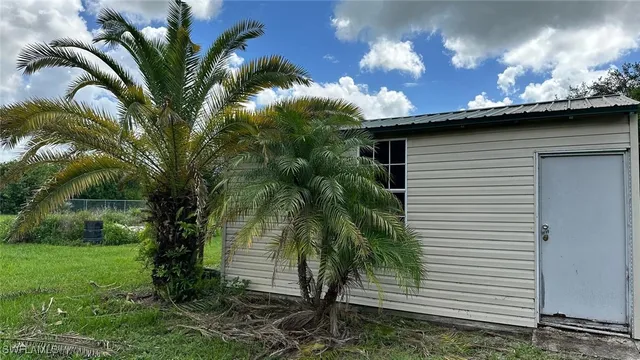a view of a house with a yard and a tree