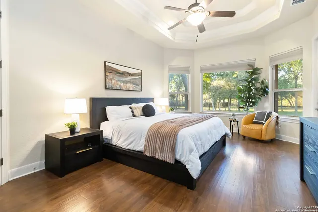 a spacious en suite bathroom with a granite countertop sink and a mirror