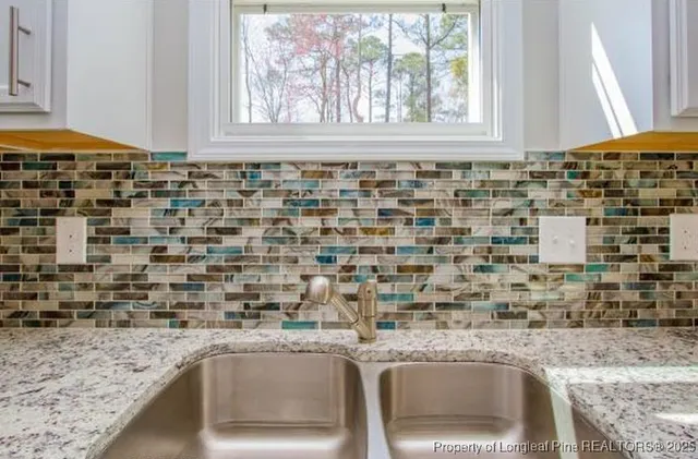 a kitchen with granite countertop sink and window