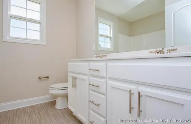 a bathroom with a sink toilet and window
