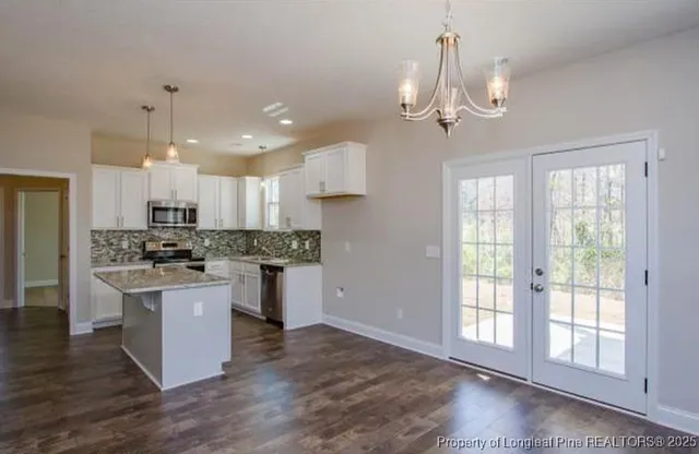 a kitchen with kitchen island a sink stainless steel appliances and window