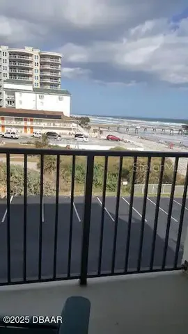 a balcony with chairs and a potted plant