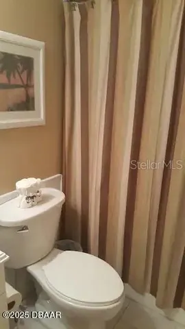 a white toilet sitting next to a white sink and tub