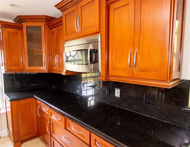 a kitchen with stainless steel appliances granite countertop a stove a sink and a microwave