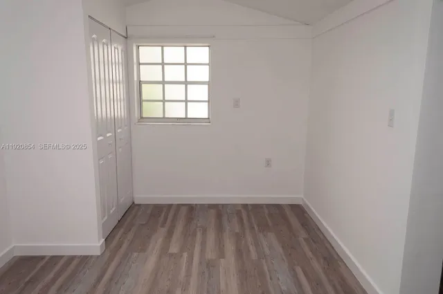a view of a room with wooden floor and windows