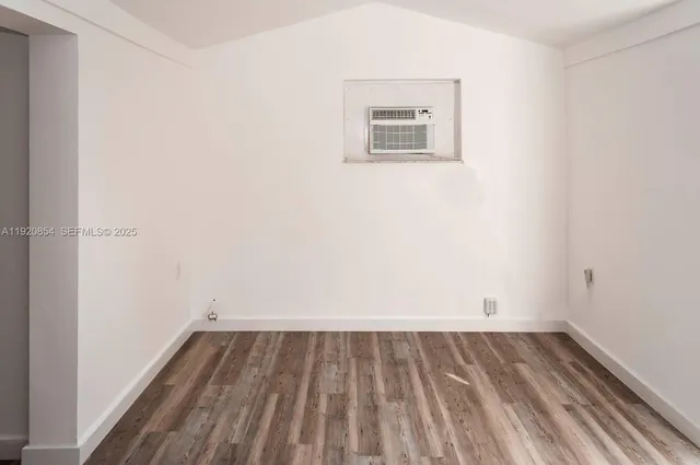 a view of a room with wooden floor and window