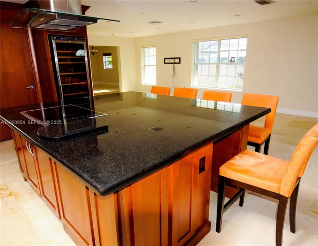 a living room with table chairs and wooden floor