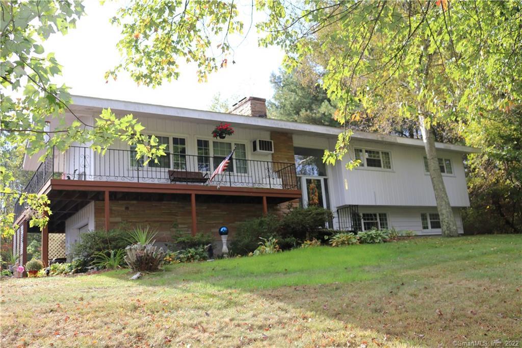 Lovely front of home with aluminum and brick and a wrap around deck.