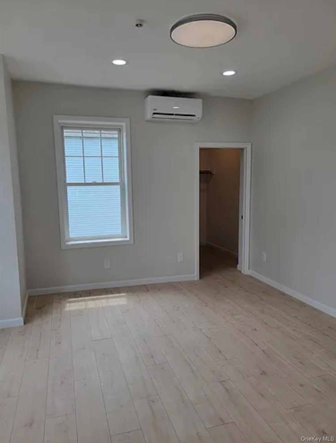 58 Smith Street, Unit 3A Poughkeepsie, NY 12601 - Photo 4 of 16 an empty room with wooden floor and windows
