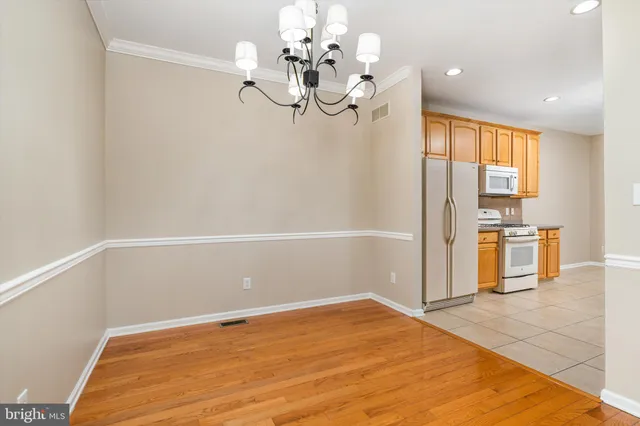 a view of a room with a cabinet and a chandelier fan