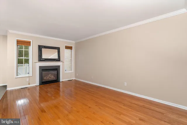 a view of an empty room with a fireplace and a window