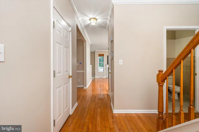 a view of a hallway with wooden floor and staircase