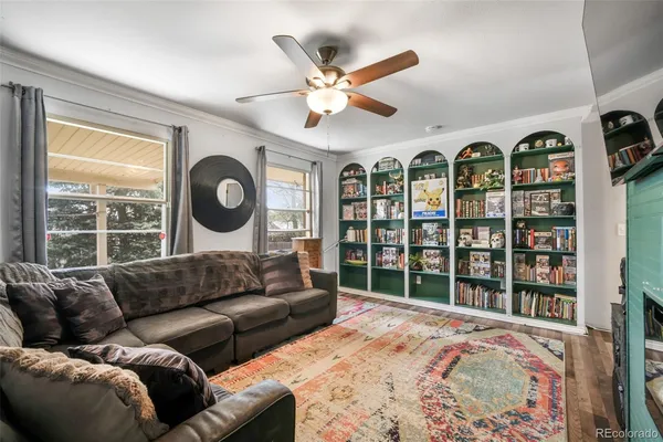 a living room with furniture a flat screen tv and a floor to ceiling window