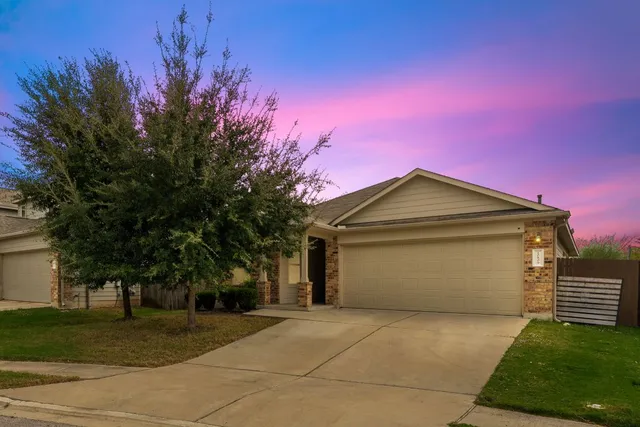 a front view of a house with a yard and trees