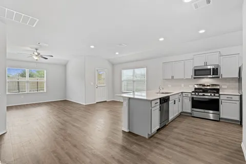 a kitchen with stainless steel appliances granite countertop a stove top oven and sink