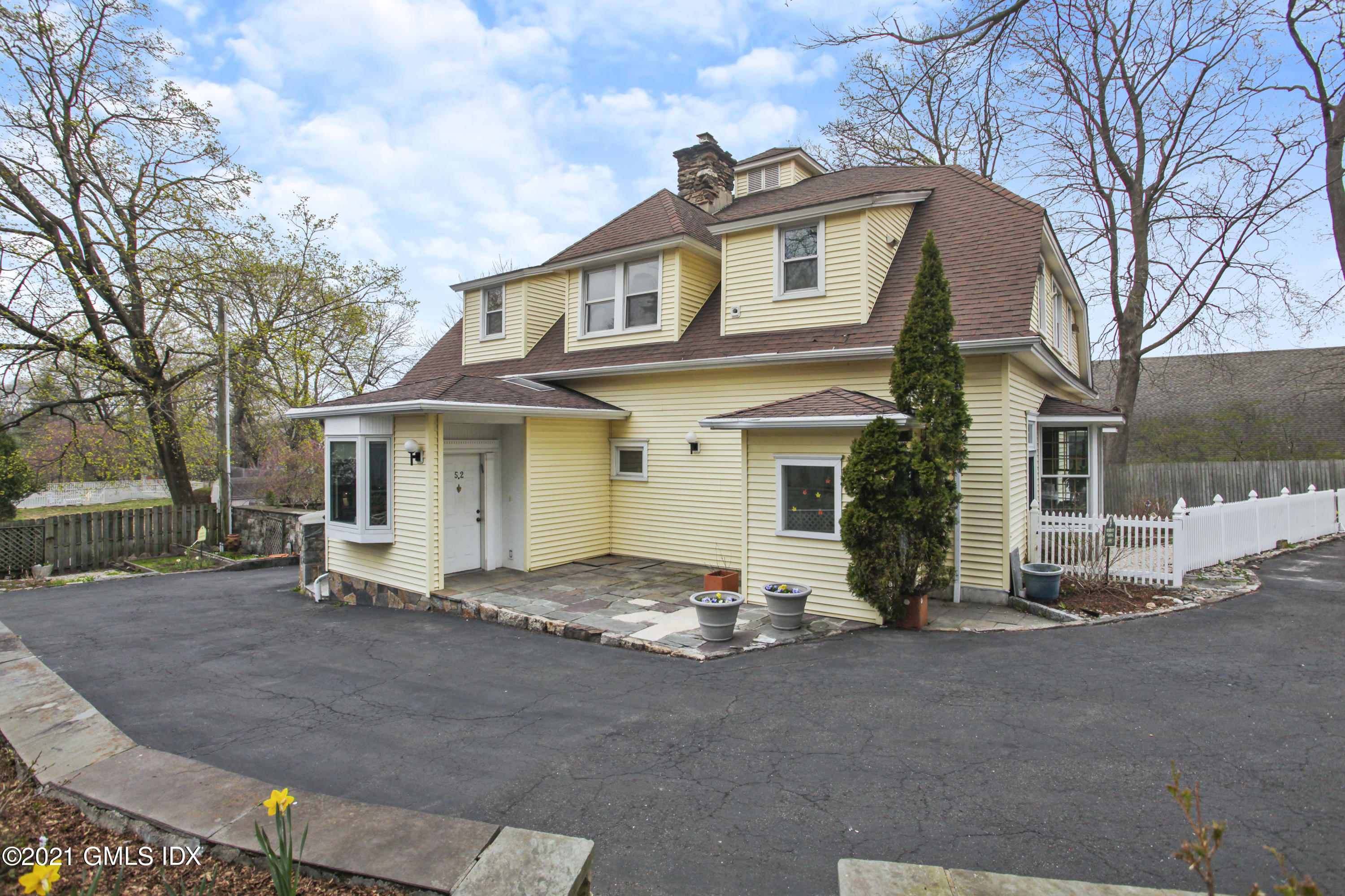 a view of a white house with large windows and a large tree