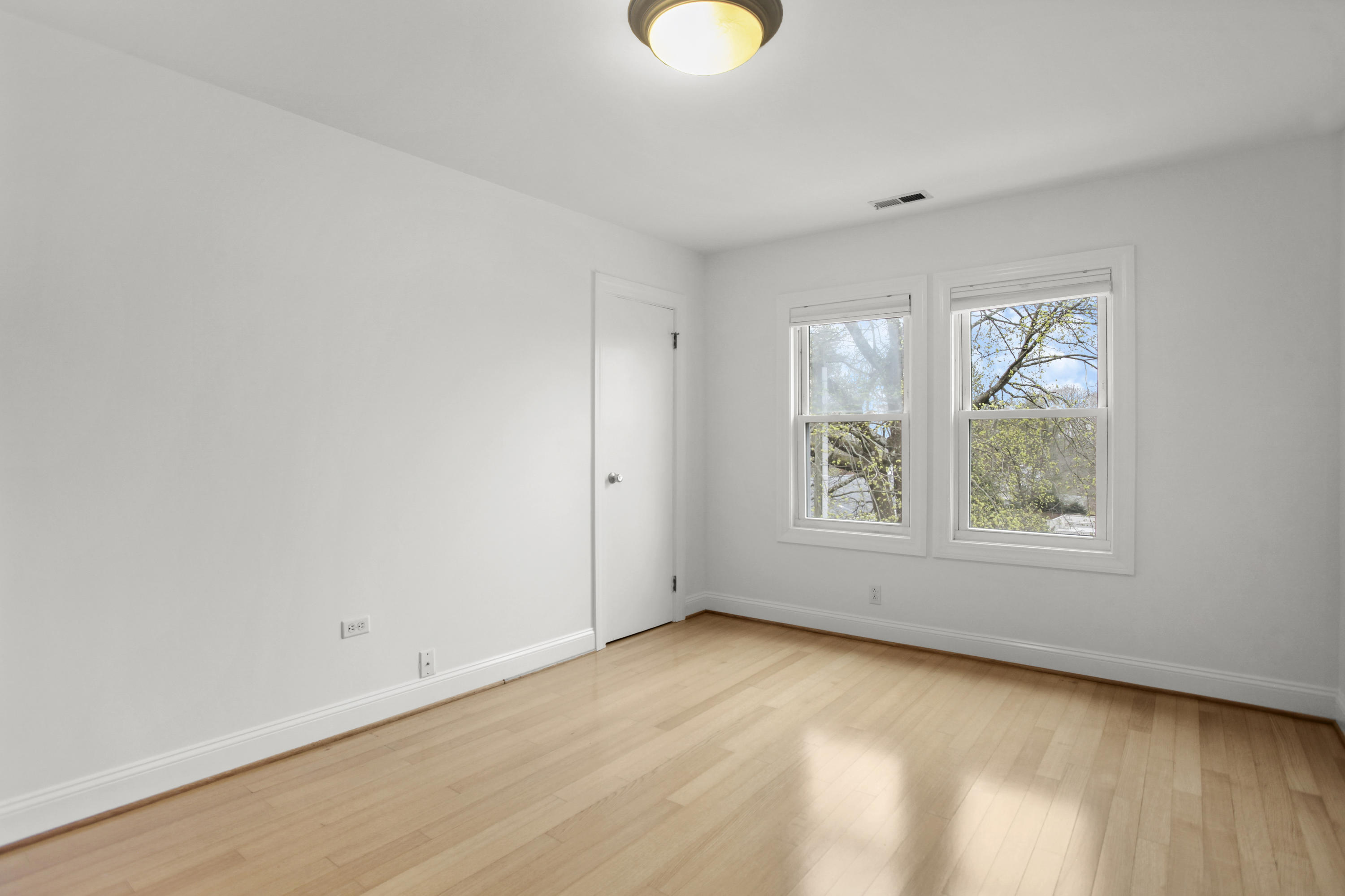 52 Bruce Park Drive, Unit B Greenwich, CT 06830 - Photo 16 of 20 a view of an empty room with wooden floor and a window