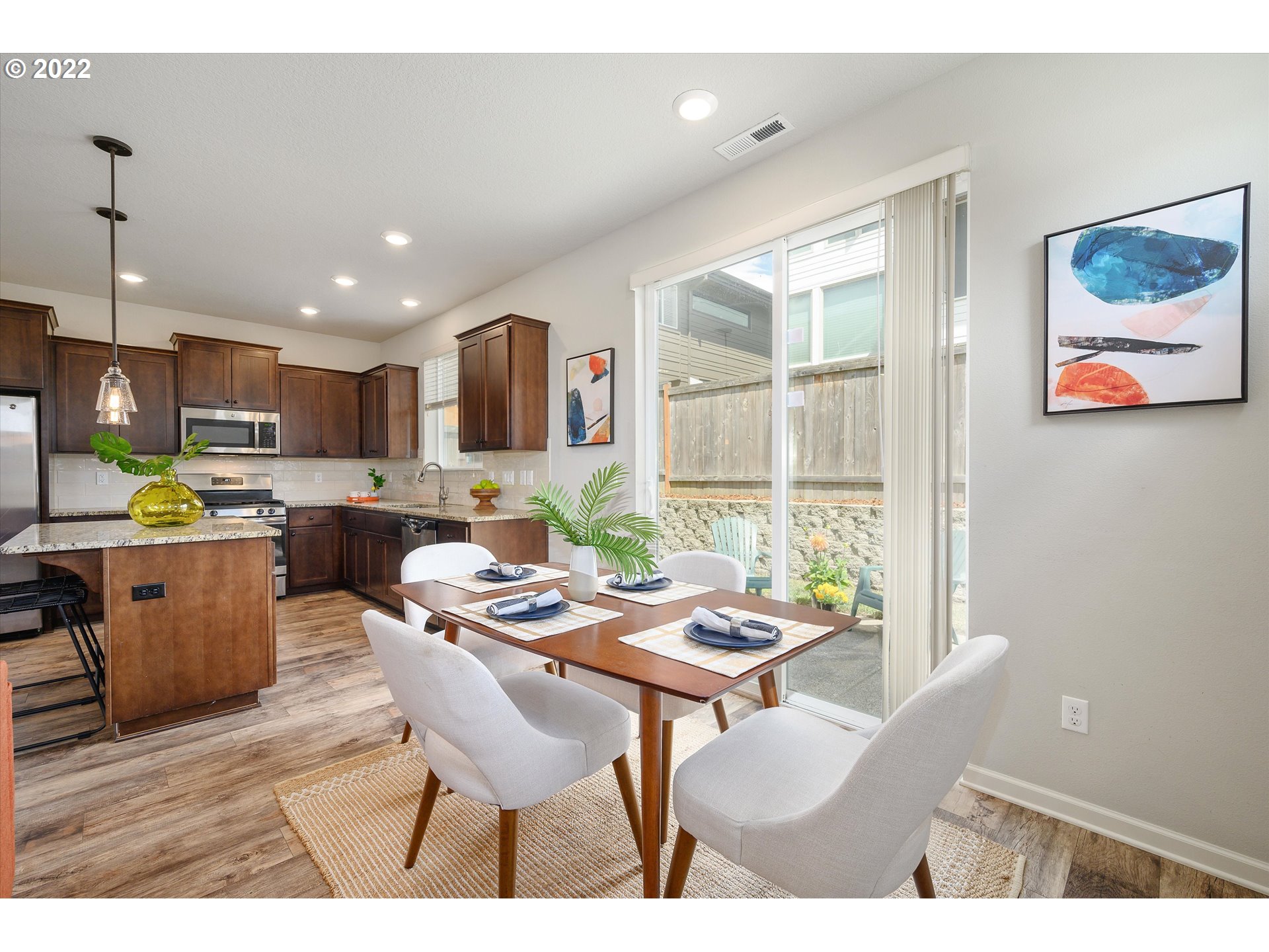 4288 Southwest Redfern Avenue Gresham, OR 97080 - Photo 16 of 32 a open dining room with stainless steel appliances kitchen island granite countertop a table chairs and a refrigerator
